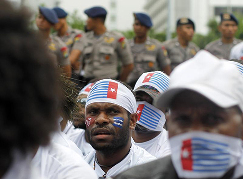 Indonesian policemen stand guard as Papuan people hold a rally  in Jakarta